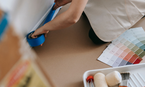 Person preparing to paint with color swatches and painting tools nearby