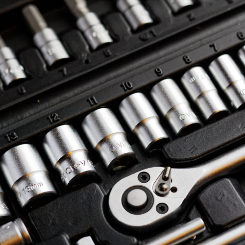 Close-up of a neatly arranged socket wrench set with chrome sockets, ratchet handle, and size markings, conveying precision and readiness.
