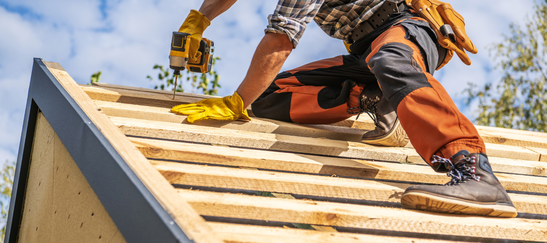 A contractor using a power drill to install a roof
