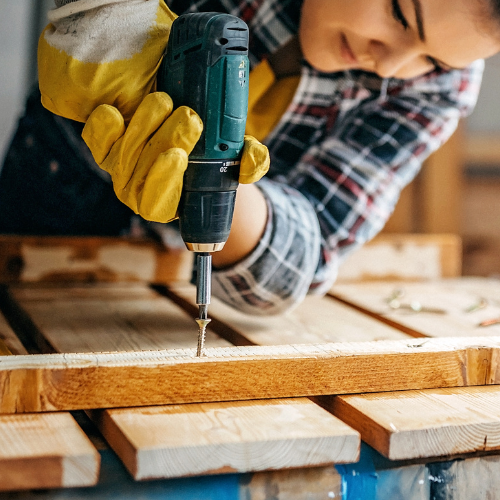 A power drill being used to install a wood screw