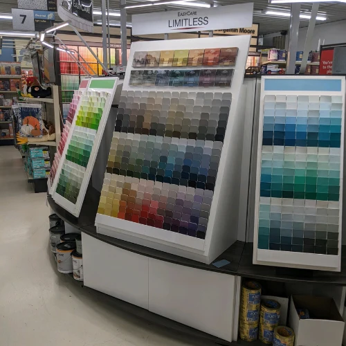 Paint store display featuring hundreds of colorful paint swatches in organized panels, creating a bright, orderly showroom scene.