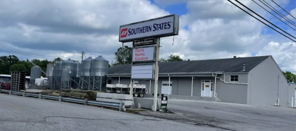 Southern States agricultural supply store with grain silos and a gray building beneath a cloudy sky.